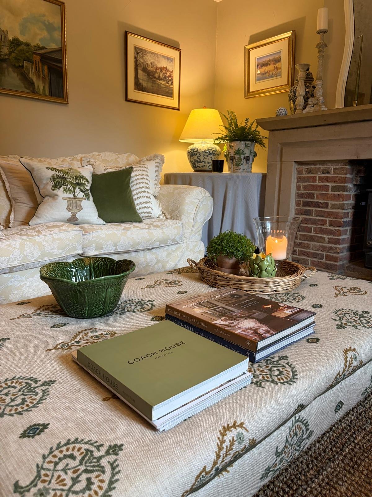 Styled living room with fireplace, candlelit tray and stacked interior design books